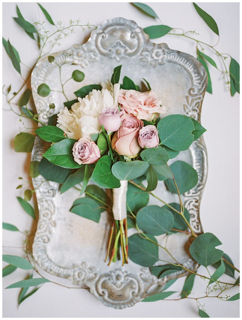 A bouquet of flowers styled on a metal tray.