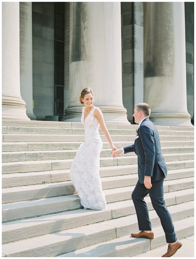 A bride and groom walking up the steps to Carnegie Library in Pittsburgh.
